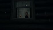 AJ stares out a cabin window.