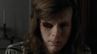 Carl enseñándole a Negan el hueco de su ojo.