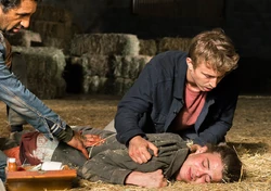 Derek ayudando a su compañero por ordenes de Travis.
