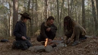 Rick, Carl y Michonne acampando en medio del bosque.