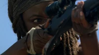 Michonne practicando su puntería con un caminante.