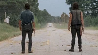 Rick y Daryl viendo a Jesus alejarse con el camión de suministros.