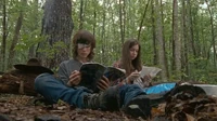 Carl y Enid sentados en el bosque, leyendo.