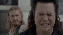 Dwight apuntando a Eugene con su arma.