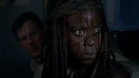 Michonne y los demás escuchando los disparos provenientes de Alexandría.