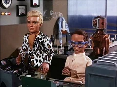 Braman standing behind Alan and Brains