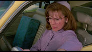 Checking her rearview mirror, Peg notices the strange gothic-like house on top of the hill.
