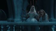 The White Queen and Alice standing on a balcony.