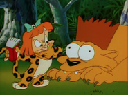 Elmyra, dressed in Cheetah fur pajamas, gives a lion a Bart Simpson haircut