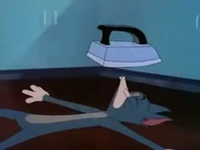 Tom próbuje odepchnąć żelazko dmuchaniem