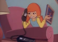 Eliza calls Marcie on the telephone and starts talking with her.