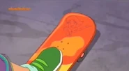 Clover signs the skateboard with a doodle of herself.