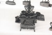 A close up of miniature cast stove in the iron display