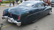Custom Merc with pinstriping, skirts, '81 Lincoln taillights, and Appletons