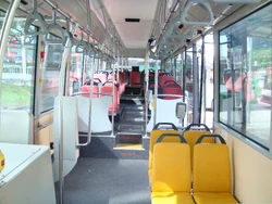 Interior of a wheelchair-accessible transit bus, with  and smart-card readers at the exit