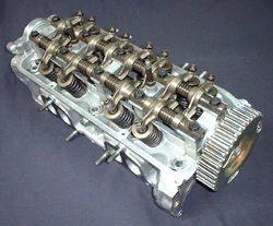 A  from a 1987  showing SOHC, rocker arms, valve springs, and other components. This is a multi-valve configuration with two intake valves and one exhaust valve for each cylinder.