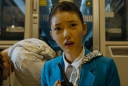 The half-turned woman rises behind Min-ji