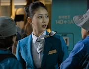 Min-ji greeting passengers boarding the train.