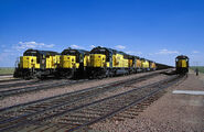 A fleet of CNW SD60 units at the head of four coal trains awaiting orders to proceed further into the Powder River Basin in Bill, Wyoming.