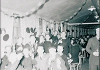 The Man with the Upside-Down Face lurking in the background of a party, taking place before a fatal accident.