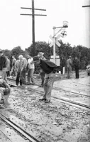 The Man with the Upside-Down Face seen observing a crowd right before disaster strikes.