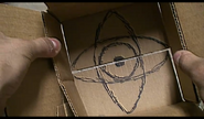 The intersecting eyes symbol, hidden under the flaps inside the box.