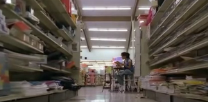 Brook Kerr as Tara Thornton, lounging in an aisle at the Super Save-A-Bunch