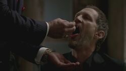 Dieter receiving Roman's blood during a meeting.