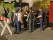 (Note: Black tack holding the workmen upright on the set can be seen)