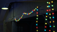 Christmas lights strung across the shed's front gable