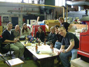Hedges-Quinn alongside several production-crew members during a party being held in the workshop during production of the tenth series