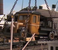 An orange-brown flatbed lorry
