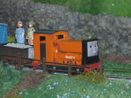 A small scale truck with a face behind a replica of Rusty at the Discover Thomas & Friends Exhibition
