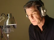 Footage of Brosnan narrating the episode