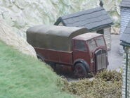 A red lorry (with a grey tarpaulin)