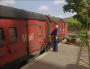 Tom Tipper leaning his bike against Percy's mail train