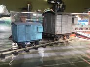 A large scale grey narrow gauge brake van and small scale blue narrow gauge brake van owned by Twitter and Instagram user ThomasTankMerch