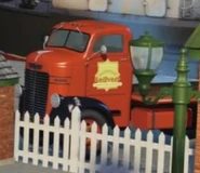 A red flatbed lorry (with black fenders)