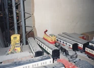 One of the ÖBB boxcars on standby with various other rolling stock in a behind the scenes photo of the third series of Thomas & Friends.