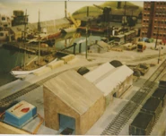 One of the Schooners, some of the coastal steamers, the LT Warehouse and the EJ LAPco TN Garage on the set of Brendam Docks in a behind the scenes photo of the third series of Thomas & Friends.