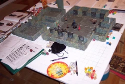 An elaborate D&D game in progress. Among the gaming aids here are dice, a variety of miniatures and a dungeon .