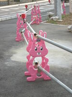 Silver roadside fence with clean, well-maintained pink bunny-shaped posts for support