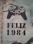 "Happy 1984" (in Spanish or Portuguese) stencil graffito, denoting  via a  controller, on a standing piece of the , 2005