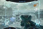 A video game screenshot. A weapon points outwards towards a snowy landscape.