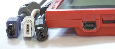 From left to right: a Game Boy Advance Game Link Cable plug, a  cable plug, a Universal Game Link cable plug, and a Game Boy Pocket link cable socket