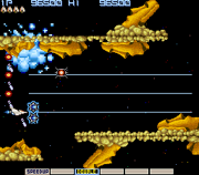 The player's ship, the Vic Viper, exchanging shots with enemy Moai in the game's third stage. The player's power meter is towards the bottom of the screen.