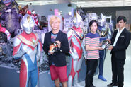 Takeshi Tsuruno, Takeshi Yoshioka, and Hassei Takano holding DVDs beside their respective Ultra alter egos