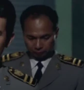 A staff officer from the TDA frequently engages in operations with Satake; portrayed by Toku Ihara (伊原 徳, Ihara Toku).