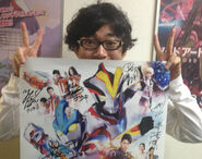 Yuki with the poster for Ultraman Ginga S, signed by the entire cast.