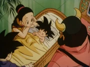 Goten as a baby, with his mother, brother, and grandfather watching him sleep in a crib